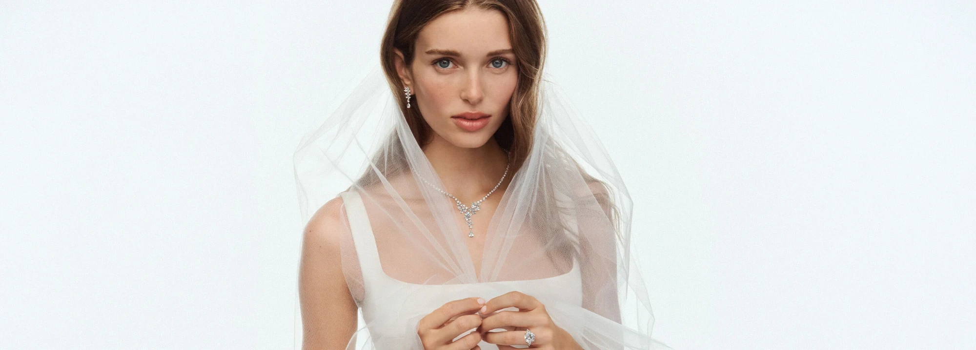 Bride wearing Arvelle diamond drop earrings and a diamond pendant necklace