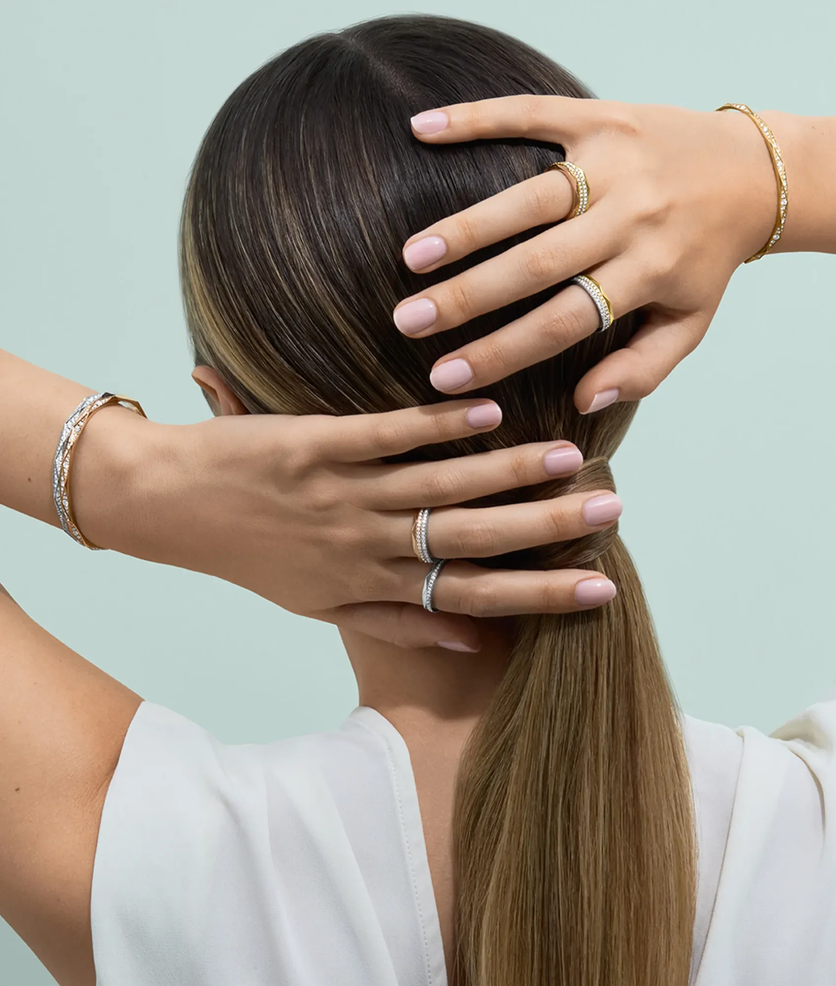 Hands wearing Arvelle diamond rings and bangle bracelets