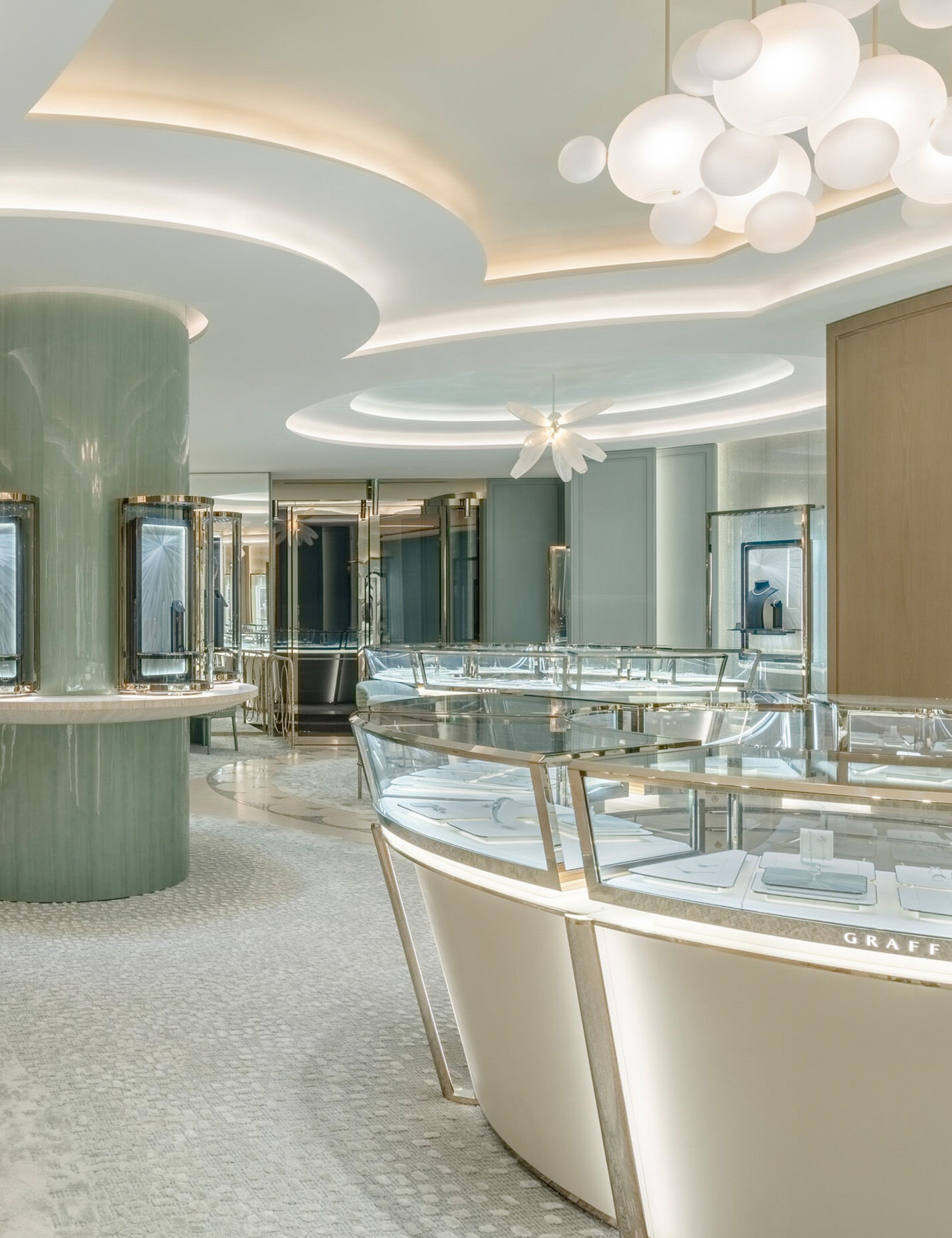 Arvelle salon boutique interior with glass display cases and a sculptural chandelier